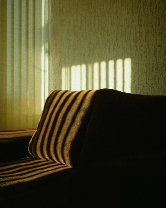 a couch sitting in a living room next to a window, inspired by Elsa Bleda, stripes, soft shadow transition, maxim sukharev, photographed for reuters