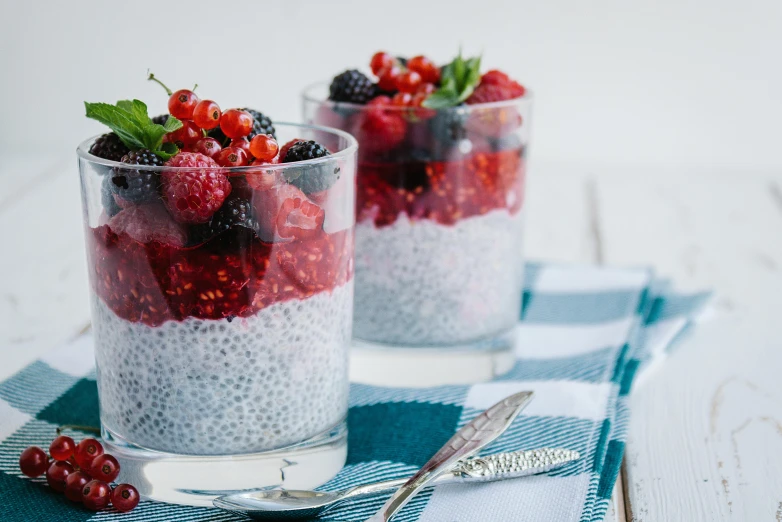 two glasses of chia pudding with berries on top, by Adam Marczyński, trending on pexels, hurufiyya, red and grey only, avatar image, rice, bright ”