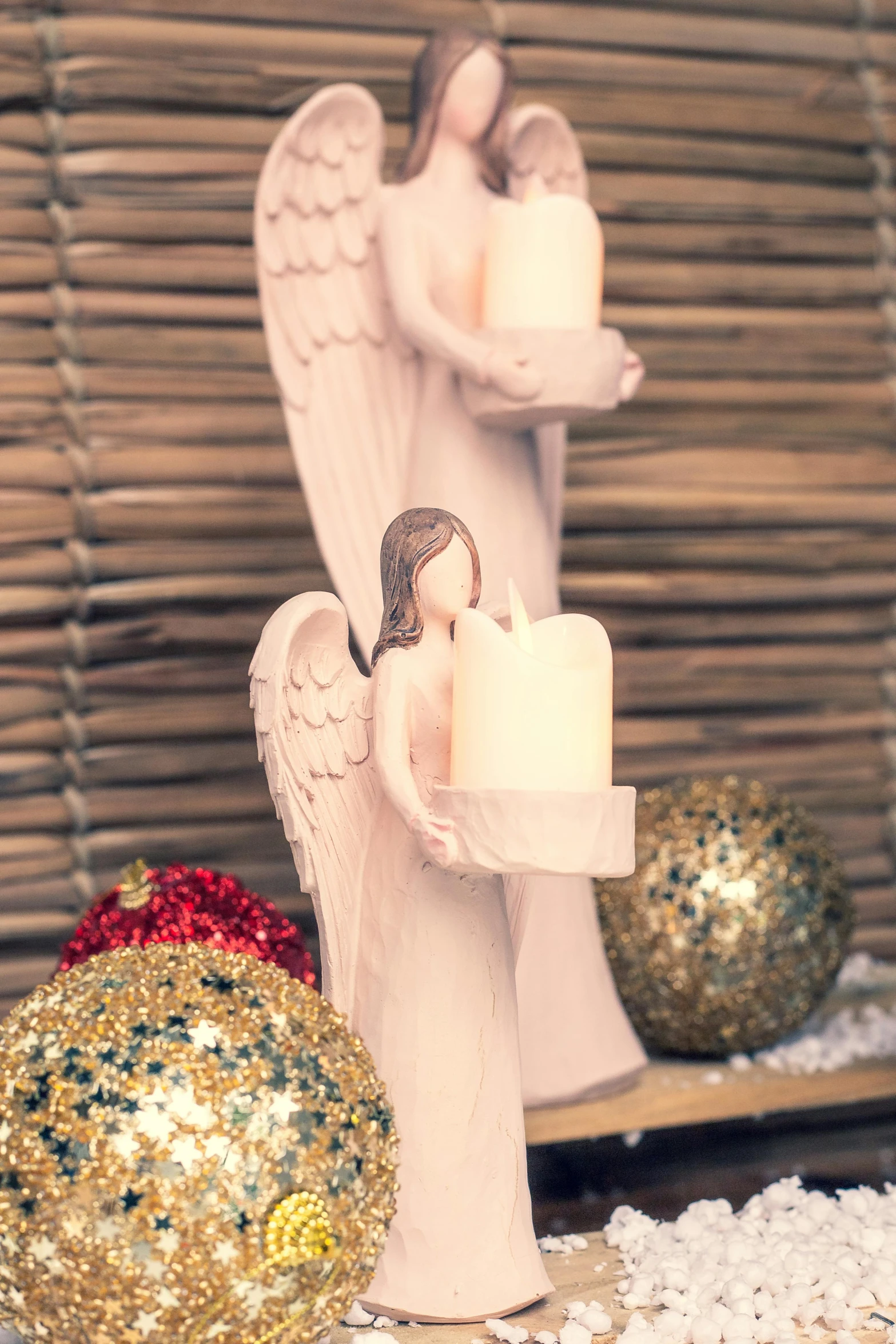 a couple of figurines sitting on top of a table, the candle is on a wooden table, wearing angel, product display photograph, holiday vibe