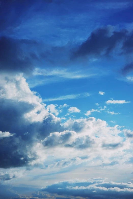 a man riding a surfboard on top of a sandy beach, a picture, unsplash, romanticism, prismatic cumulus clouds, blue, sitting in a fluffy cloud, aesthetic clouds in the sky