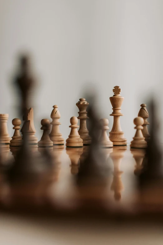 a group of chess pieces sitting on top of a wooden table, zoomed in, on display, game board