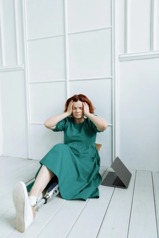 a woman in a green dress sitting on the floor, trending on pexels, tinnitus, sitting on a chair, frustrated detailed, a redheaded young woman