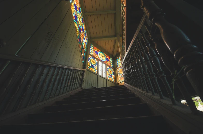 a stairway leading up to a stained glass window, an album cover, inspired by Francisco Oller, unsplash contest winner, haunted house interior, multicoloured, ornate wood, alessio albi