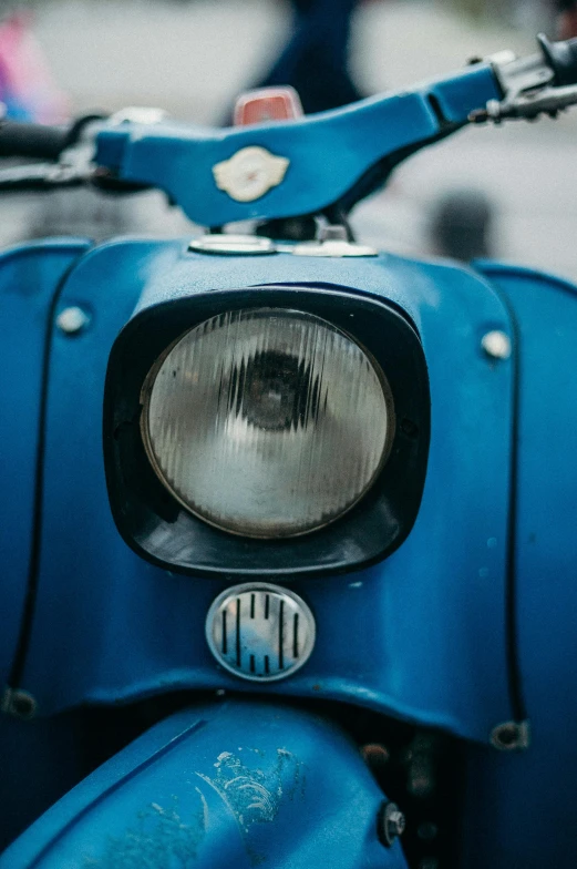 a close up of a blue motor scooter, by Adam Marczyński, trending on unsplash, 1957, headlights, looking into camera, 1952