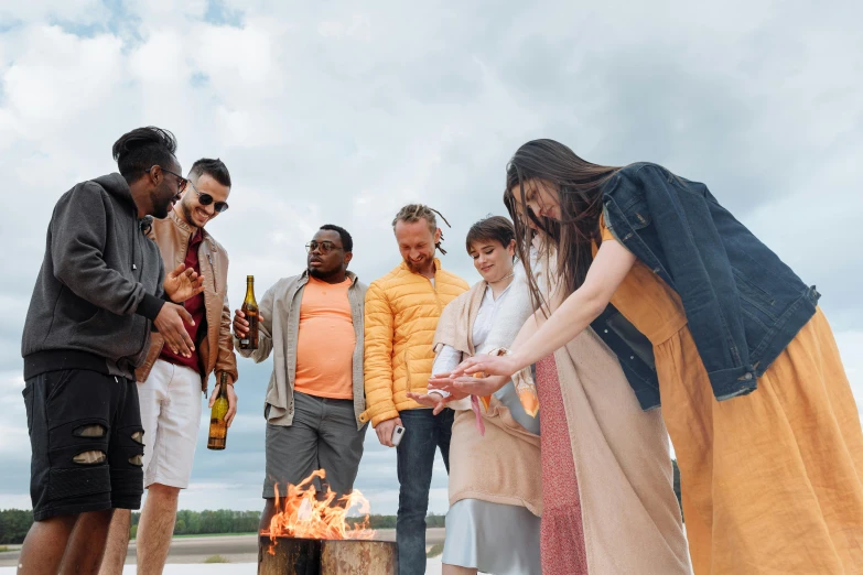 a group of people standing around a fire pit, pexels contest winner, diverse outfits, picnic, bright sky, brown