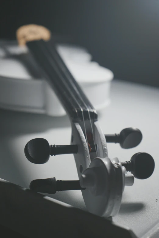 a close up of a violin on a table, by Dan Christensen, pexels contest winner, bauhaus, on a gray background, back lit, tournament, 15081959 21121991 01012000 4k