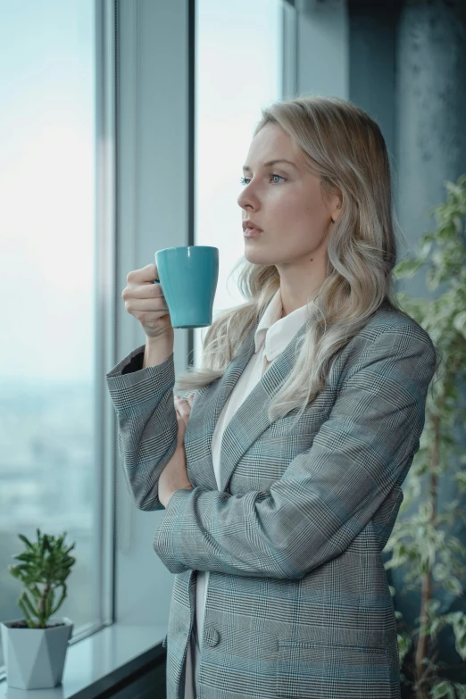 a woman in a business suit holding a cup of coffee, a colorized photo, pexels contest winner, renaissance, contemplative, soft grey and blue natural light, blonde swedish woman, teal energy