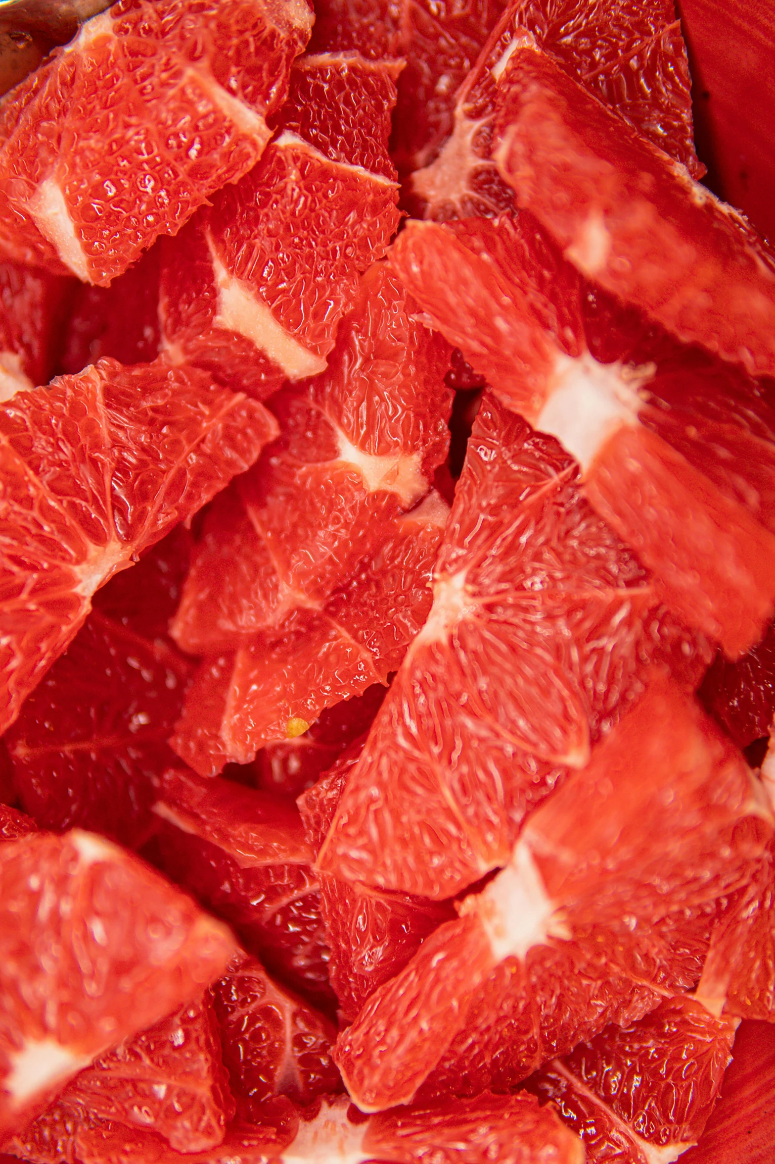 a red bowl filled with cut up grapefruits, pexels, hurufiyya, dynamic closeup, neck zoomed in, beef, multi - layer