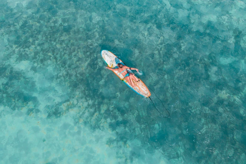 a person riding a surfboard on top of a body of water, a picture, turquoise and orange, birdseye view, canoe, inflatable