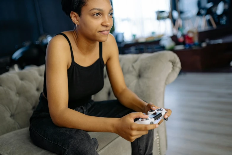 a woman sitting on a couch holding a video game controller, pexels, black teenage girl, titanfall irl, avatar image, professional image