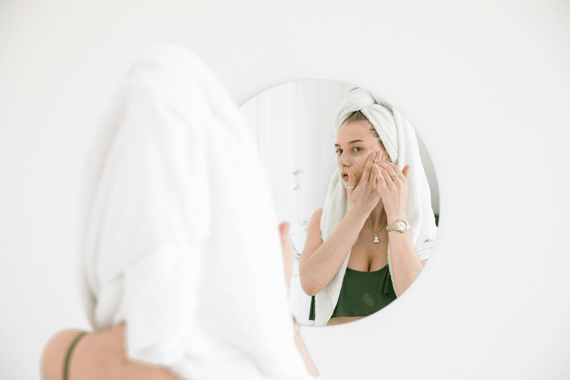 a woman wiping her face in front of a mirror, a picture, by Nicolette Macnamara, trending on pexels, with a white background, manuka, wētā fx, square facial structure