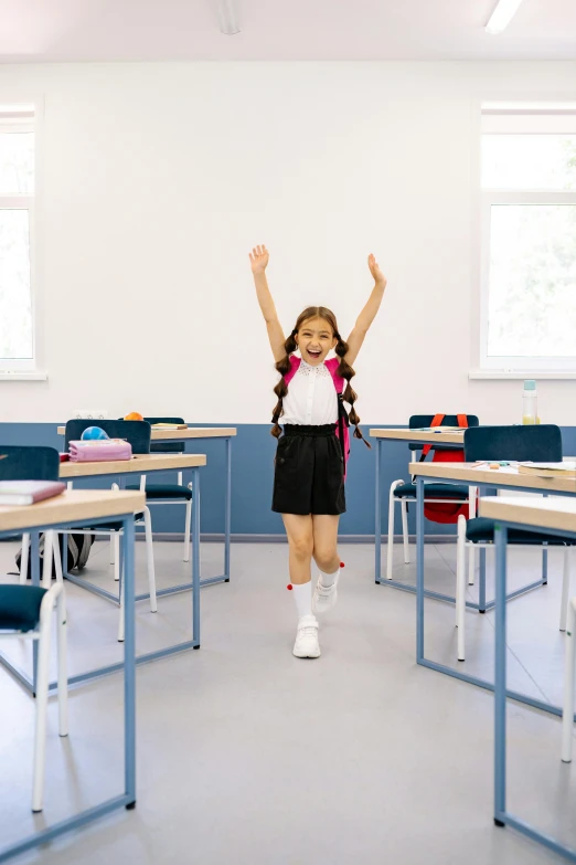 a girl jumping up in the air in a classroom, pexels contest winner, danube school, standing on a desk, official product photo, all overly excited, in the middle of an empty room