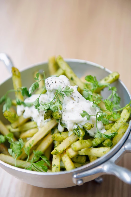 a close up of a bowl of food on a table, inspired by Pia Fries, green and white, daily specials, cream, rocket