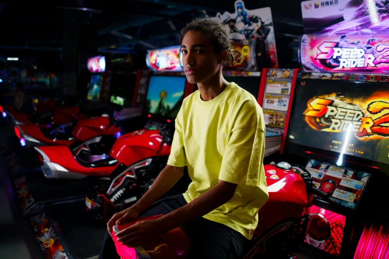 a man sitting on top of a red motorcycle, a portrait, unsplash, neogeo, a busy arcade, black teenage boy, taken in the late 2010s, teddy fresh