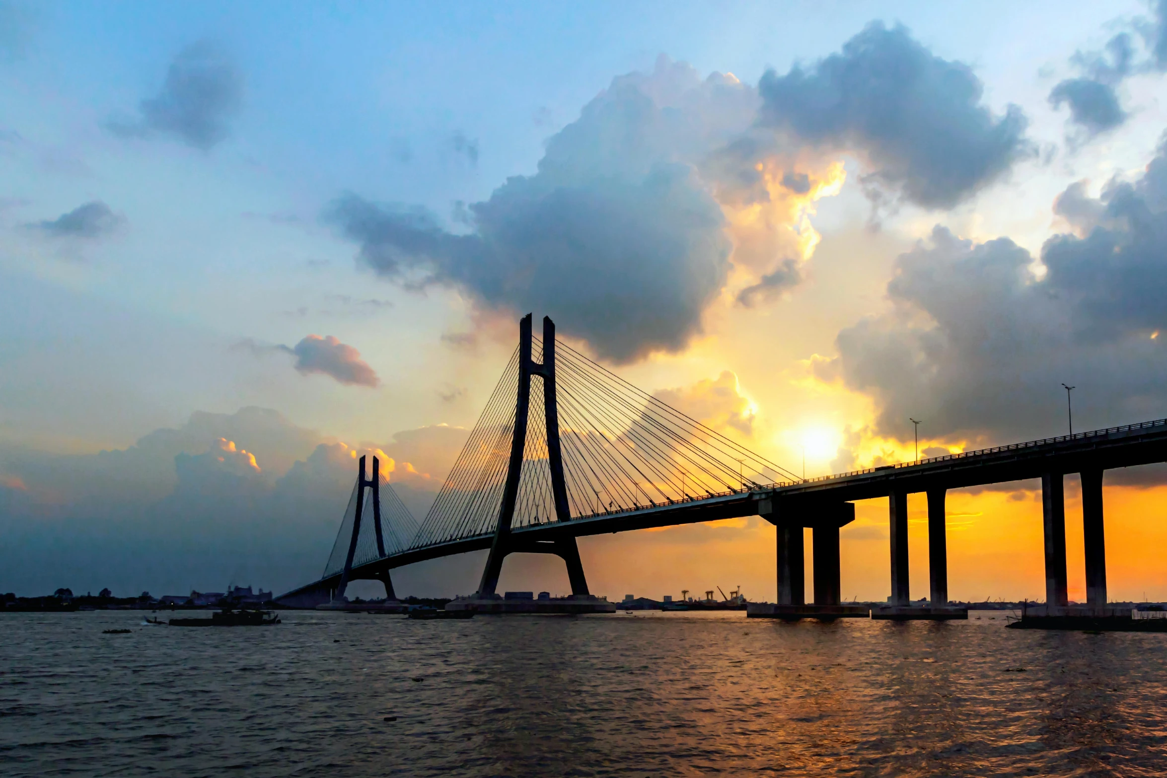 a bridge over a body of water under a cloudy sky, sun set, calcutta, guangjian, profile image