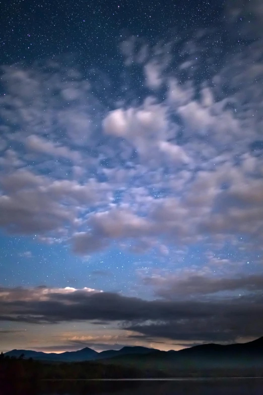 a large body of water under a cloudy sky, a picture, by Linda Sutton, stars and paisley filled sky, photograph, christopher alexander, with overhead cloudy!!!!! skies