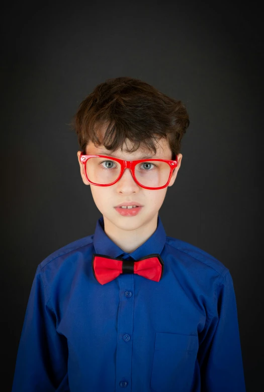 a young boy wearing red glasses and a bow tie, inspired by George Henry, incoherents, avatar image, professional photograph, red and blue garments, fluorescent