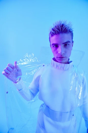 a man in a white outfit holding a plastic bag, an album cover, inspired by David LaChapelle, antipodeans, zac efron, blue spiky hair, covered in circuitry, blue turtleneck