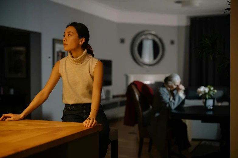 a woman sitting at a table in a living room, by Adam Marczyński, pexels contest winner, hyperrealism, scene from live action movie, evening time, medium shot of two characters, an asian woman