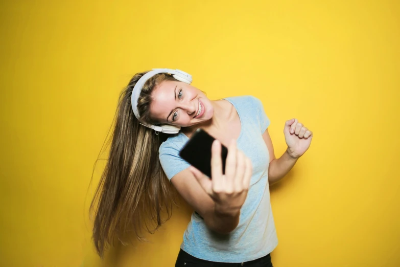 a woman taking a selfie with her cell phone, an album cover, trending on pexels, happening, wearing yellow croptop, wearing a headband, avatar image, dance