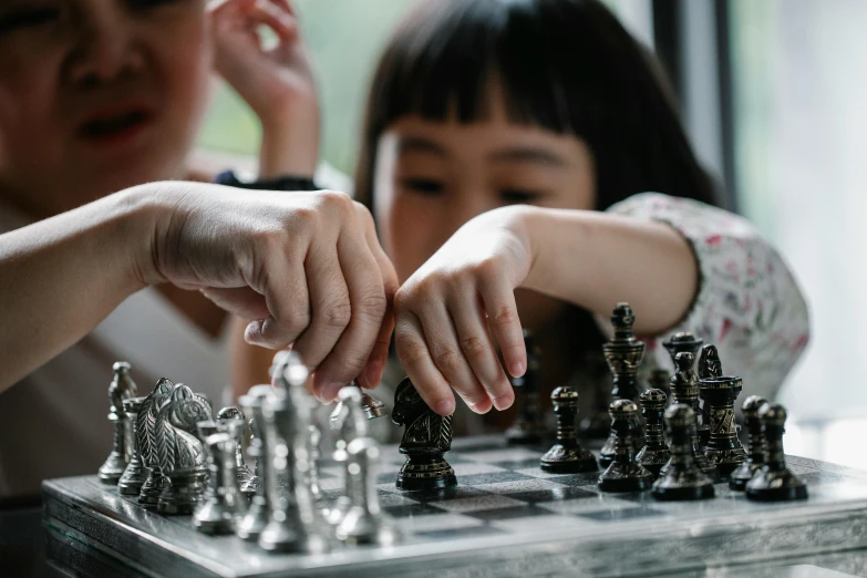 a little girl playing a game of chess with her mother, pexels contest winner, visual art, shiny silver, 🦩🪐🐞👩🏻🦳, handmade, joy ang