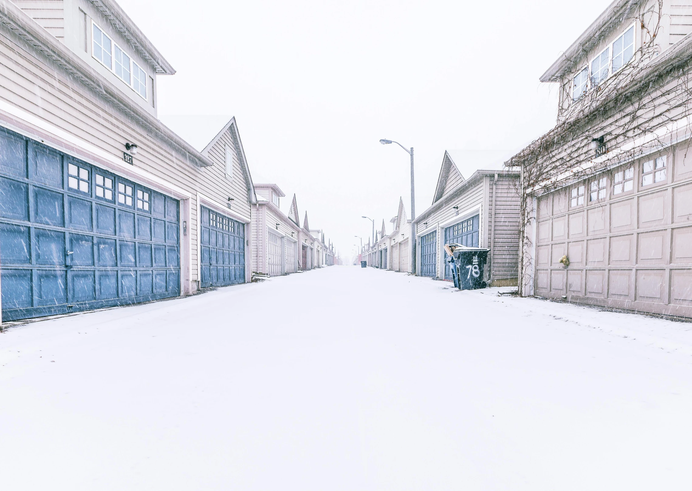 a red fire hydrant sitting in the middle of a snow covered street, an album cover, by Ryan Pancoast, pexels contest winner, white houses, white plank siding, rows of doors, cold blue colors