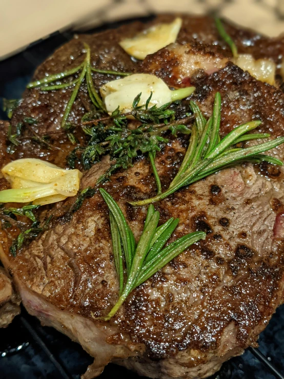 a steak sitting on top of a black plate, profile image