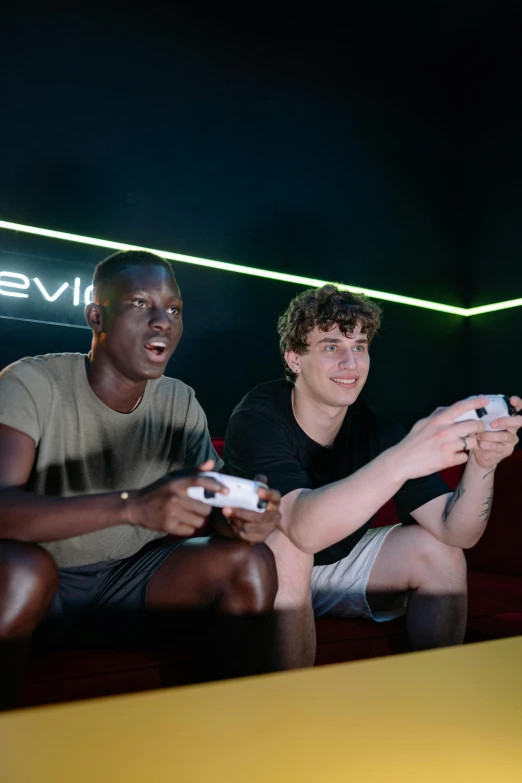 two men sitting on a couch playing a video game, pexels, f 1 driver charles leclerc, graded with davinci resolve, chillin at the club together, nvidia promotional image