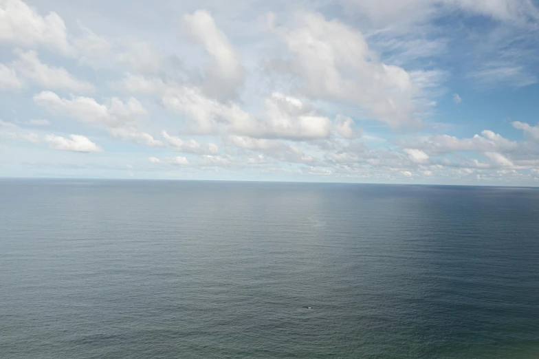 a large body of water next to a beach, by Daniel Lieske, pexels contest winner, minimalism, flying over the horizon, 2 5 6 x 2 5 6 pixels, very cloudy sky, helicopter view