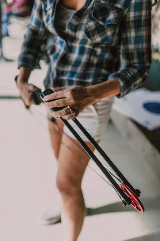 a woman in plaid shirt holding a pair of skis, pexels contest winner, renaissance, crossbow arrow, skinny upper arms, 3 d print, gif