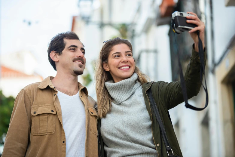 a man and a woman taking a selfie, holding a camera, profile image, spanish, visa pour l'image