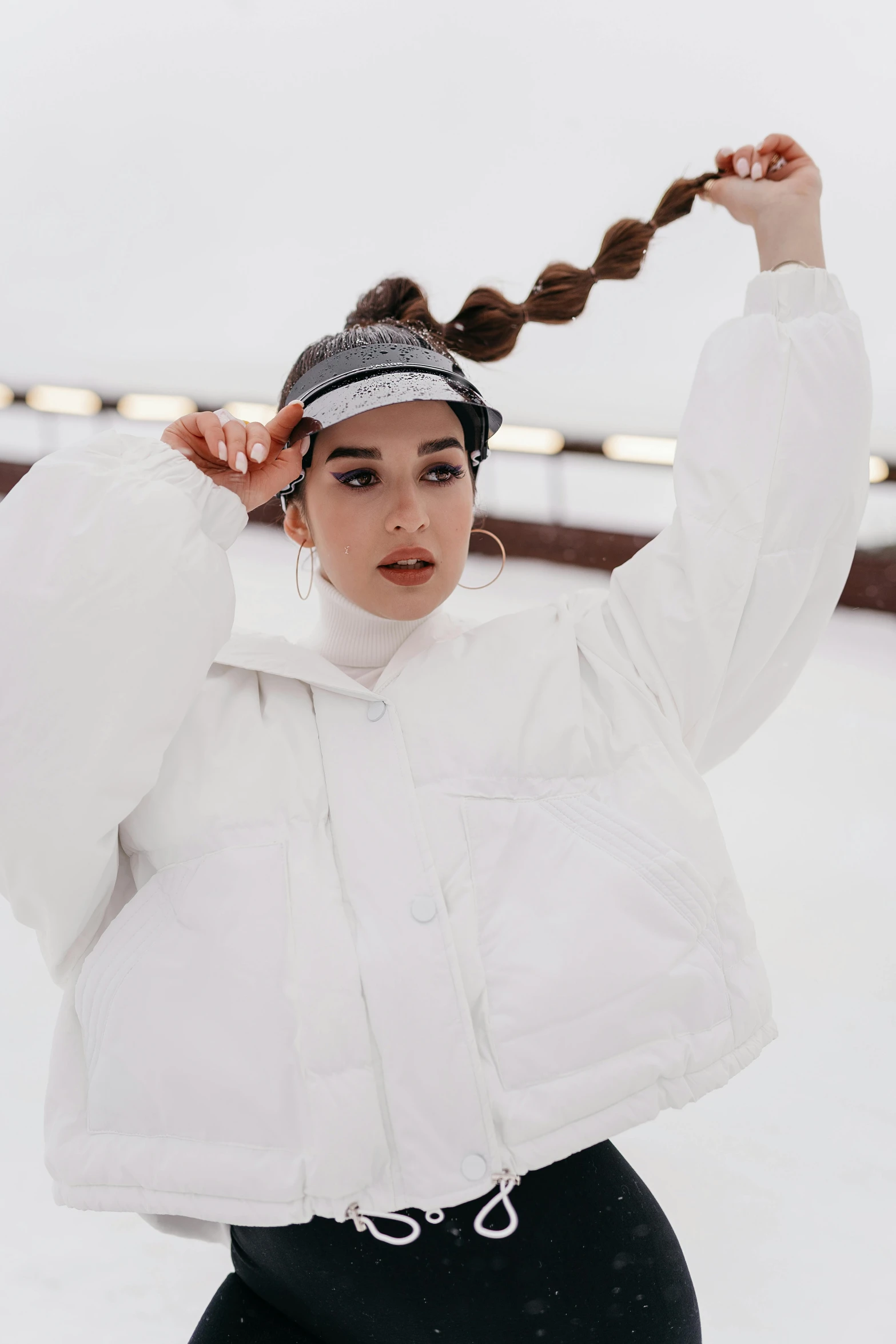 a woman that is standing in the snow, an album cover, inspired by Louisa Matthíasdóttir, trending on pexels, white baseball cap, portrait sophie mudd, wearing a track suit, covered!! hair