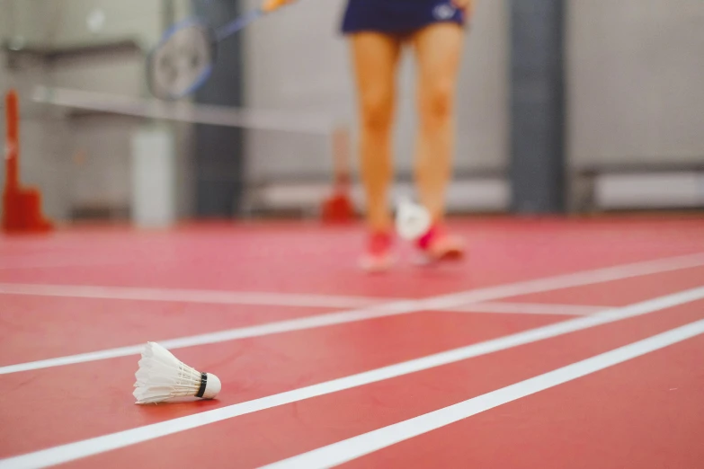 a woman standing on top of a tennis court holding a racquet, trending on dribble, fibres trial on the floor, badminton, running towards the camera, university