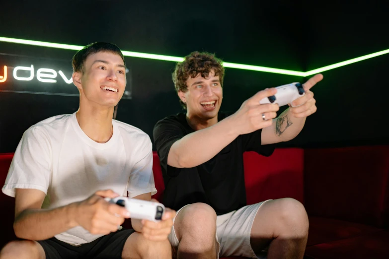 two men sitting on a couch playing a video game, unsplash, avatar image, sports photo, lazertag, charli bowater and artgeem