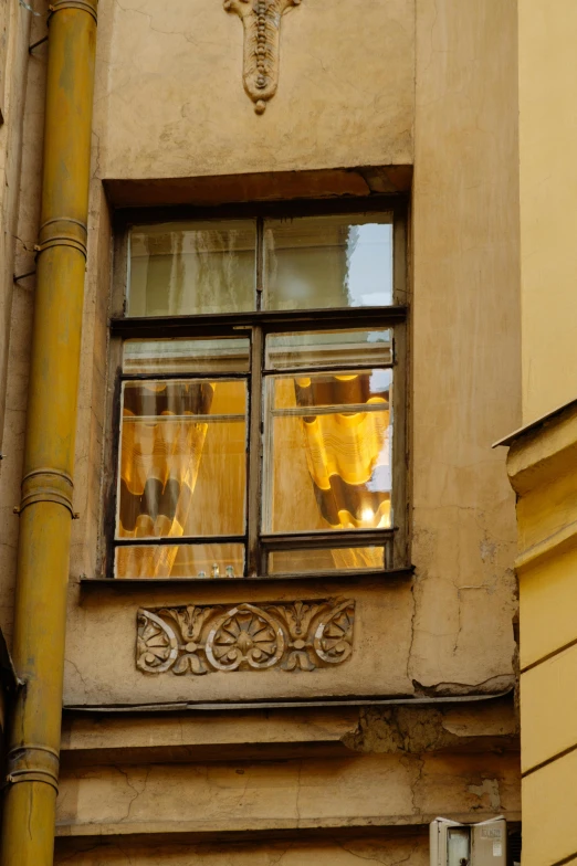 a clock that is on the side of a building, inspired by Kazimierz Alchimowicz, beautiful drapes, yellow hue, looking out of the window, partially glazed