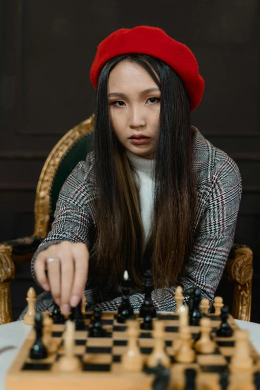 a woman in a red beret playing chess, a portrait, trending on pexels, asian human, wearing a crown and suit, gif, serious