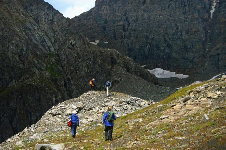 a group of people hiking up the side of a mountain, a photo, glacier national park, avatar image, gigapixel photo