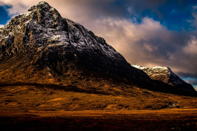 a mountain covered in snow under a cloudy sky, by Peter Churcher, pexels contest winner, scottish folklore, deep colours. ”, brown, thumbnail