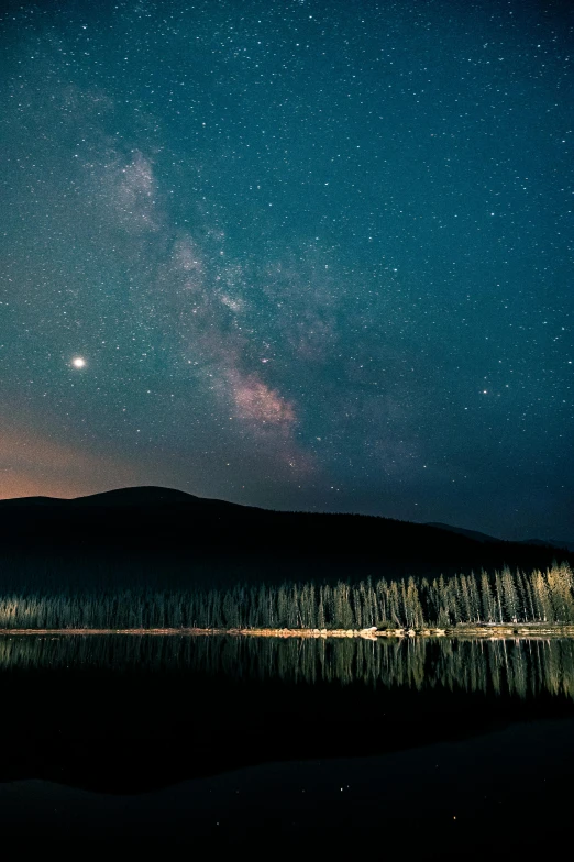 a body of water with a mountain in the background, by Matt Cavotta, trending on unsplash, space art, stars and moons in the sky, new hampshire, visible planets in the sky, tree in a galaxy made of stars