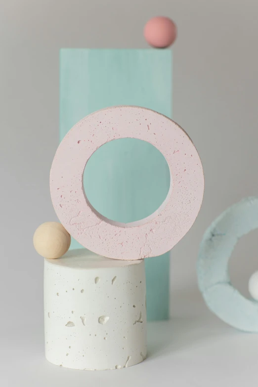 a close up of a wooden object on a table, inspired by jeonseok lee, trending on unsplash, concrete art, pink frosted donut, modern pastel colours, with small object details, large moon