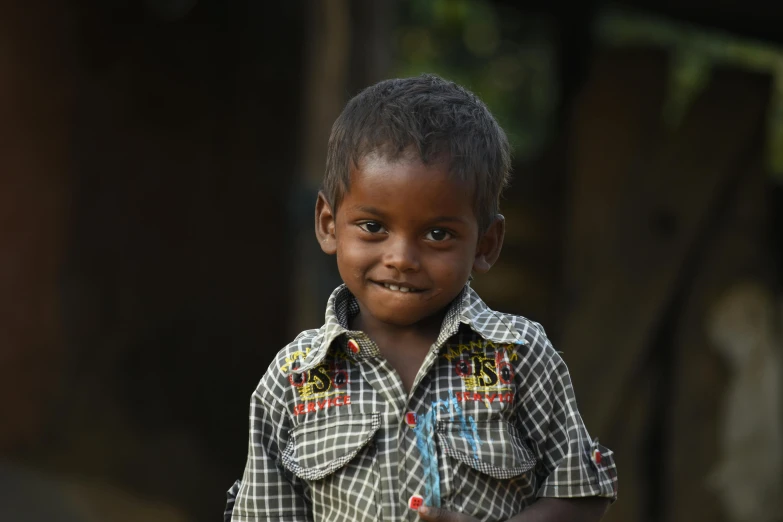 a young boy in a plaid shirt holding a toothbrush, pexels contest winner, hurufiyya, in a village, jayison devadas, almost smiling, with brown skin