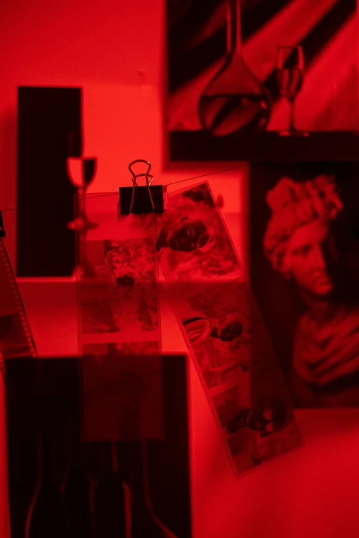 a couple of pictures sitting on top of a table, inspired by Nan Goldin, unsplash, red neon details, collection of louvre, picture frames, fine details. red