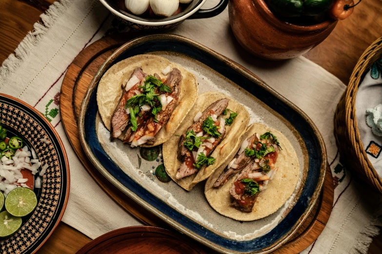 a group of tacos sitting on top of a wooden table, profile image, on a plate, múseca illil, thumbnail