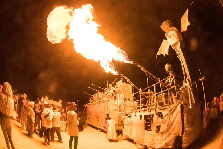 a group of people standing around a burning boat, unsplash contest winner, kinetic art, military tank fury road, witchlight carnival, performing, yellow lighting from right