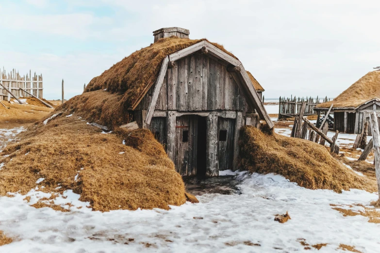a pile of hay sitting on top of a snow covered field, pexels contest winner, renaissance, inside a medieval hobbit home, reykjavik, gambrel roof building, brown