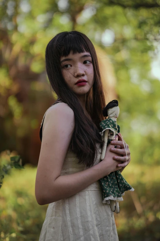 a woman holding a doll in a forest, inspired by Junji Ito, unsplash, portrait of a japanese teen, mai anh tran, ( ( theatrical ) ), mini model