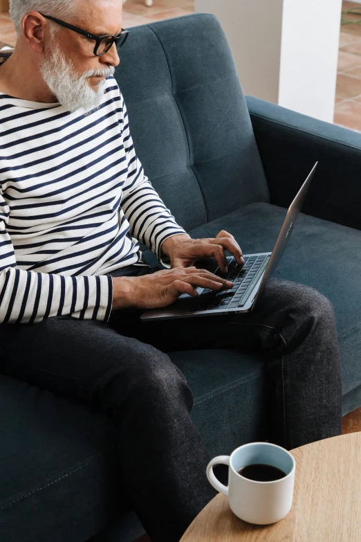 a man sitting on a couch using a laptop, by Carey Morris, pexels, older woman, rounded lines, instagram photo, casually dressed