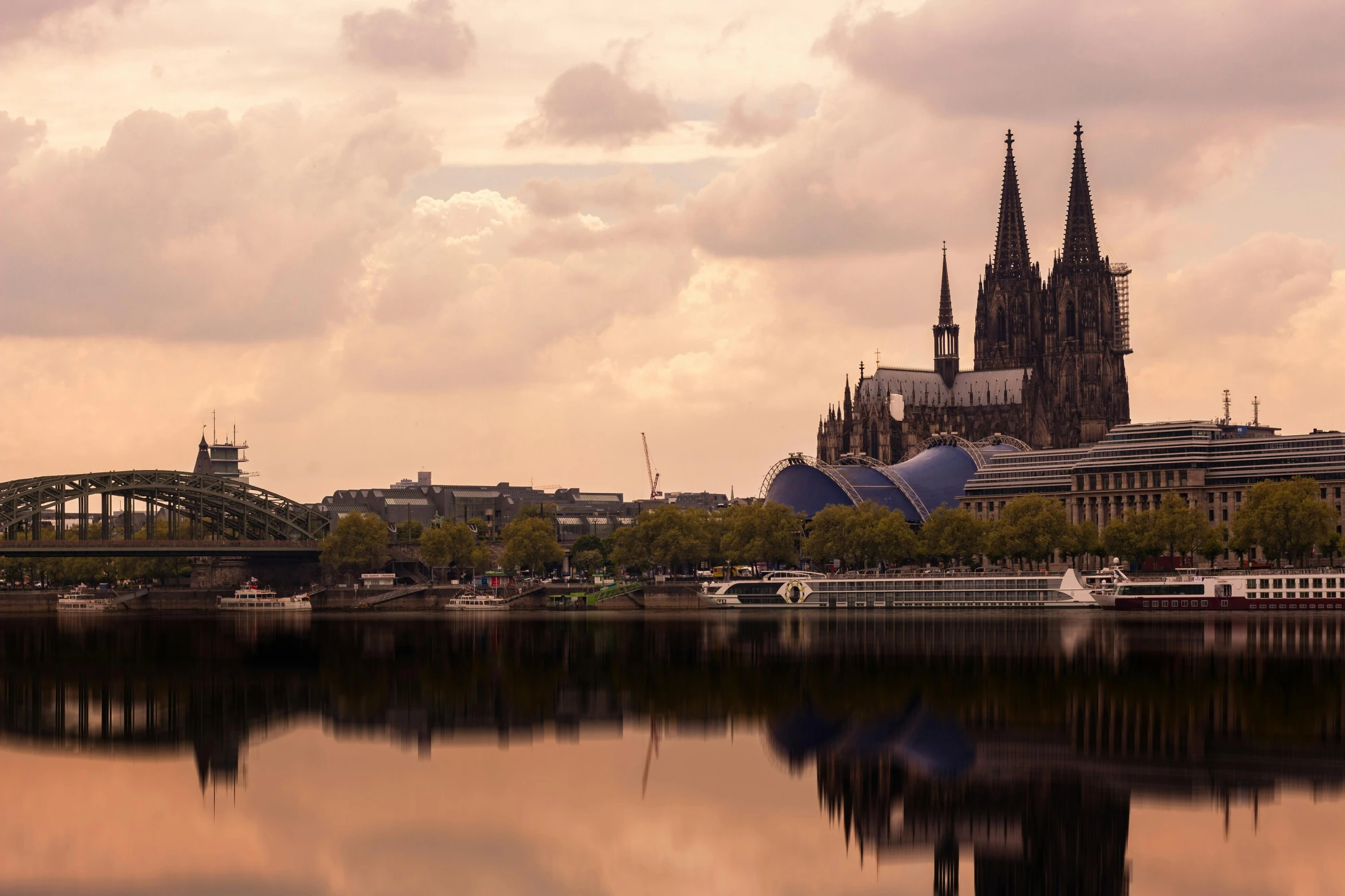 a large body of water with a bridge in the background, by Thomas Häfner, pexels contest winner, art nouveau, majestic spires, pink, brown, german