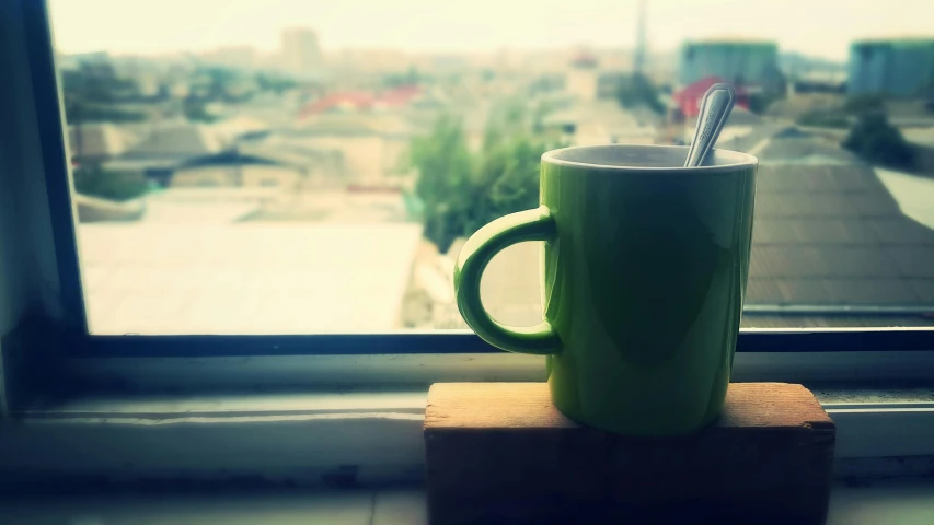 a green cup sitting on top of a wooden block, a picture, inspired by Muggur, unsplash, happening, window view, square, lo fi, really long