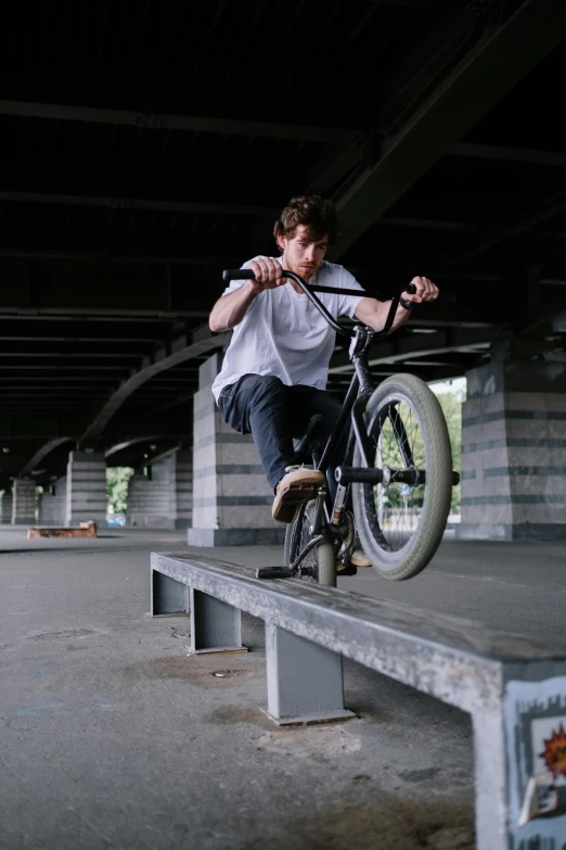 a man riding a bike up the side of a ramp, inspired by Seb McKinnon, bench, in an action pose, damp, boys